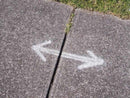 Seta desenhada num pavimento com o Spray Marcação Temporária da Montana Colors. Este spray pode ser útil para a marcação de percursos em caminhadas ou provas de trail, corta-mato ou btt.