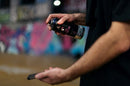 Pormenor de pessoa a utilizar o Spray Desinfetante de Superfícies para higienizar um telemóvel smartphone.