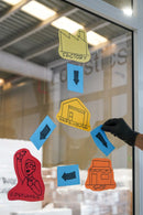 Papeis colocados na montra de uma loja com o Spray MTN Repositionable Adhesive da Montana Colors.