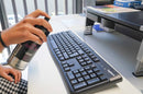 Pormenor de pessoa a utilizar o Spray MTN Universal Surface Cleaner para higienizar um teclado de coputador.