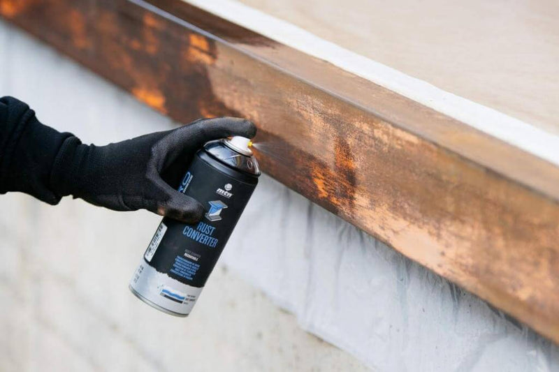 Pormenor do Spray Primário Conversor de Ferrugem a ser utilizado numa superfície metálica. A pintura será aplicada de seguida, sendo que esta aplicação prévia melhora a aderência da tinta.