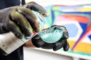 Aplicador a utilizar o Transfer Cap para transferir tinta de um spray da Montana Colors para uma paleta de cores.